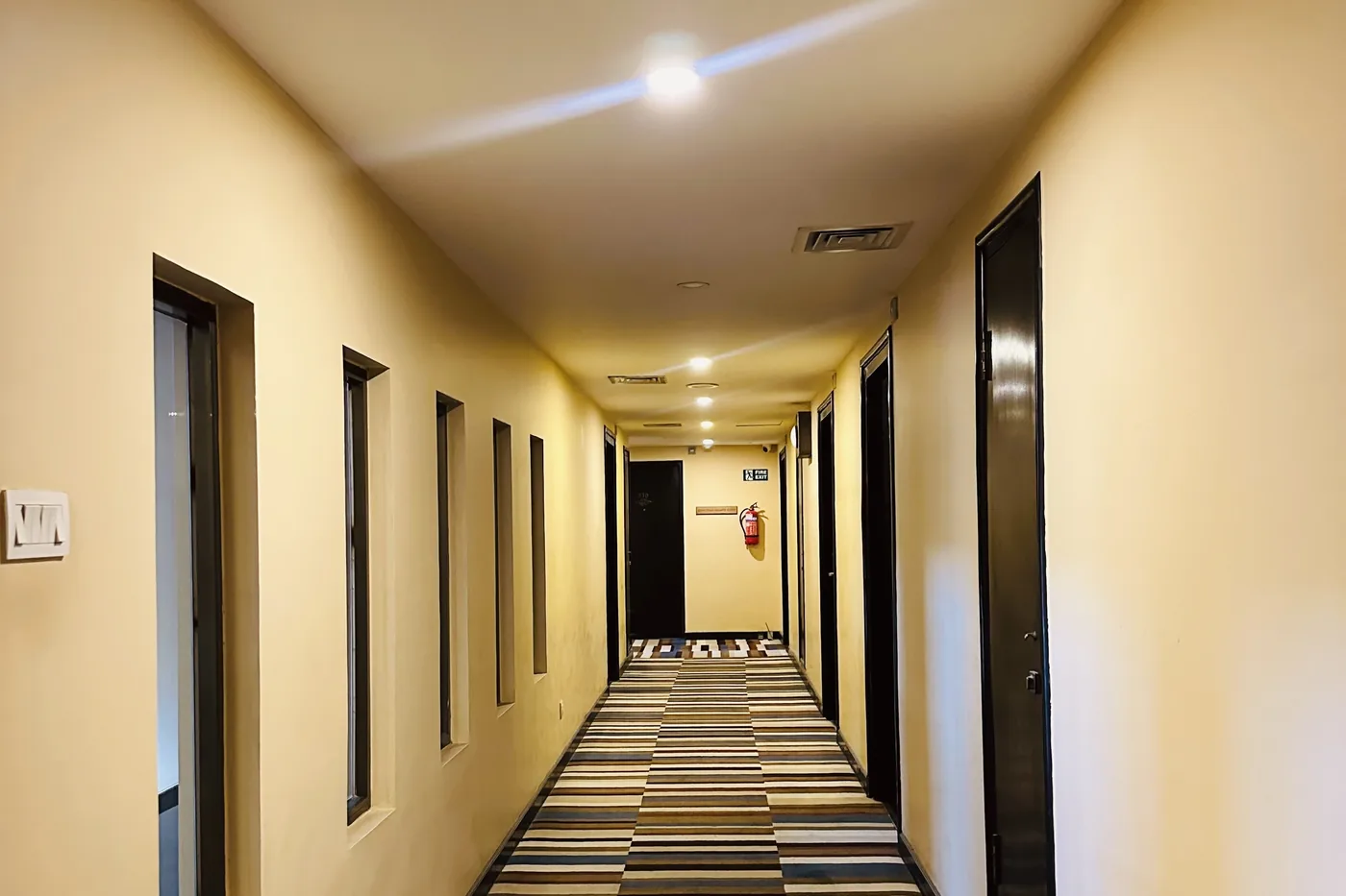 Çizgili halı kaplı otel koridoru